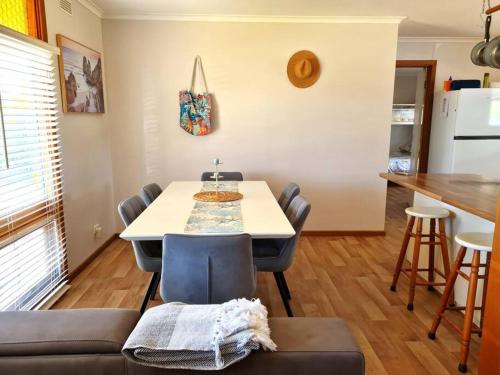 a room with a table and chairs and a kitchen at Lil Blue Beach House in Port Hughes