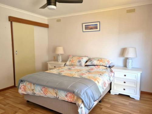 a bedroom with a bed with two night stands and two lamps at Lil Blue Beach House in Port Hughes