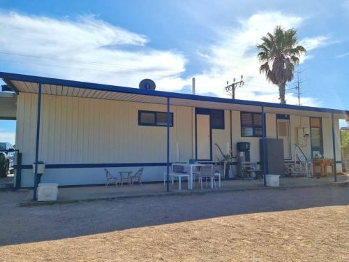 a building with tables and chairs in front of it at Lil Blue Beach House in Port Hughes