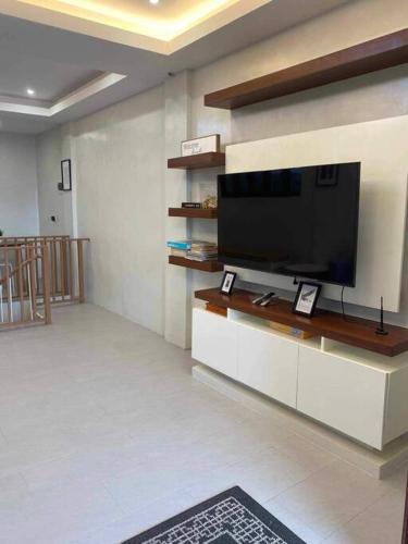 a living room with a flat screen tv on a wall at Staycation San Jose Del Monte City in Santo Cristo