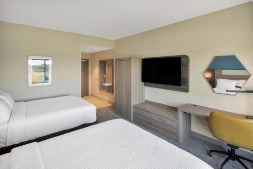 a hotel room with two beds and a television at Holiday Inn Express & Suites Fort Walton Beach - Eglin Area by IHG in Fort Walton Beach