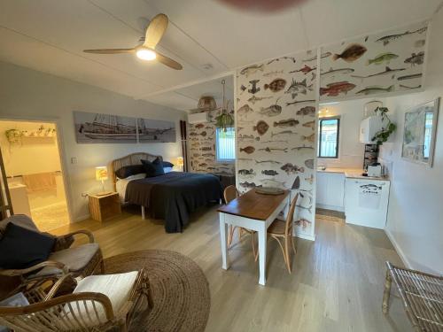 a living room with a bed and a table in a room at MrandMrs Fish Cabins in American River