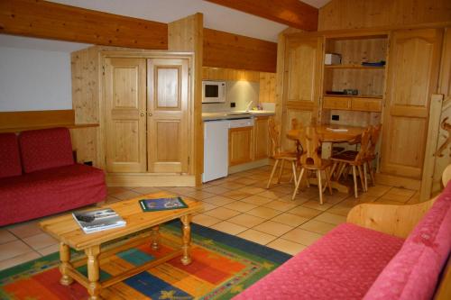 a living room with a red couch and a table at Chalet Lafarge in Courchevel