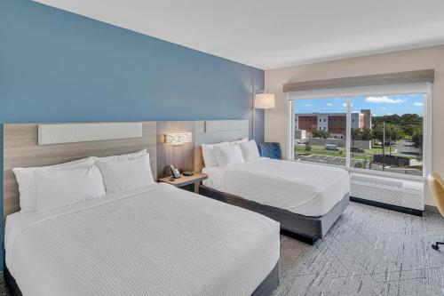 a hotel room with two beds and a window at Holiday Inn Express & Suites Fort Walton Beach - Eglin Area by IHG in Fort Walton Beach