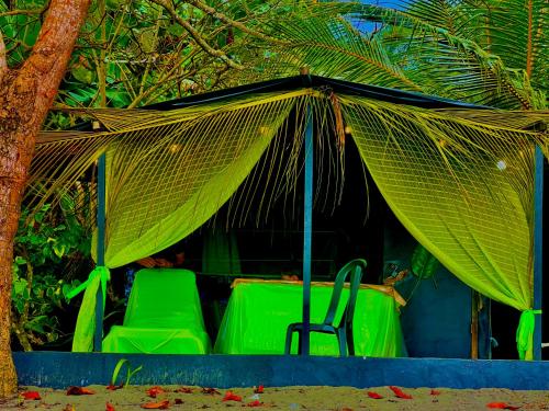 a group of green chairs sitting under a net at Beachfront Paradise in Manuel Antonio