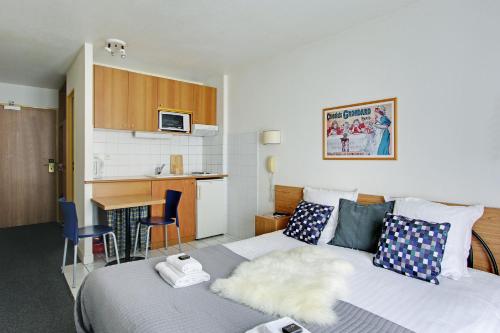 een hotelkamer met een bed en een keuken bij Les Lilas Serviced Apartments in Les Lilas