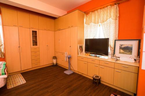 台東市的住宿－小燕子民宿，一间卧室设有橙色的墙壁和平面电视。