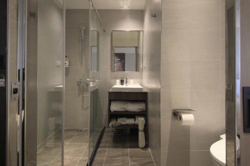 a bathroom with a shower and a sink and a toilet at Tango Inn Taipei Kaifong in Taipei
