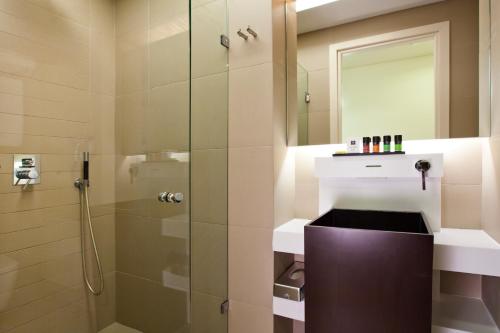 a bathroom with a shower with a glass door at O&B Athens Boutique Hotel in Athens