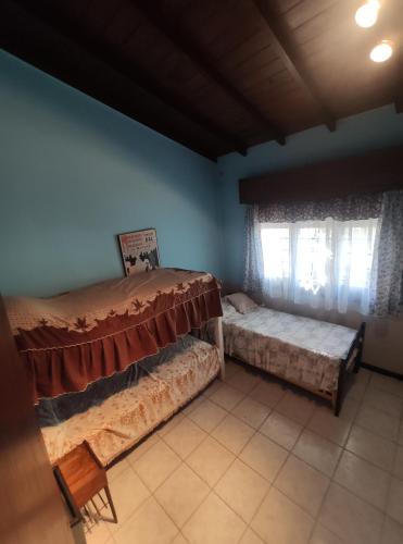 a room with two beds and two windows at Casa Gesell in Villa Gesell