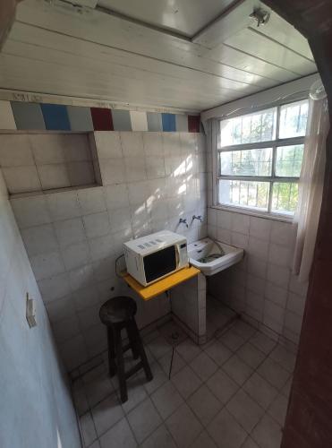 a small kitchen with a microwave and a sink at Casa Gesell in Villa Gesell