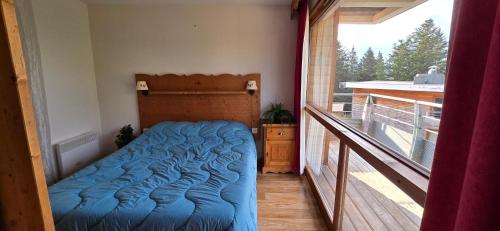 Ce lit se trouve dans une chambre dotée d'un balcon. dans l'établissement Appartement au pied des pistes et du park nordique, à Chamrousse