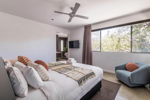 a bedroom with a bed and a chair and a window at Peppermint Sands in Dunsborough