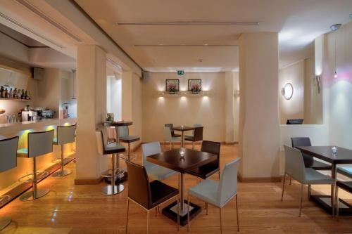 a restaurant with tables and chairs and a counter at O&B Athens Boutique Hotel in Athens