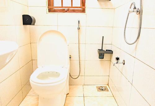 a bathroom with a toilet and a shower at Kiba Cotagges in Wakiso