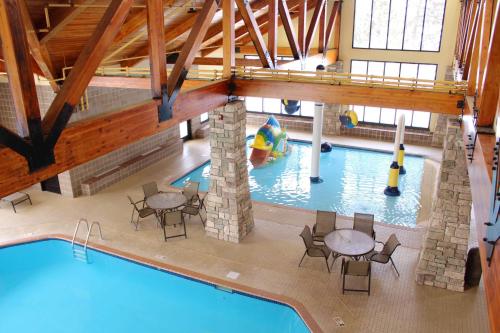 a pool with tables and chairs in a indoor swimming pool at SouthShore Hotel on Lake Bemidji, Trademark Coll by Wyndham in Bemidji
