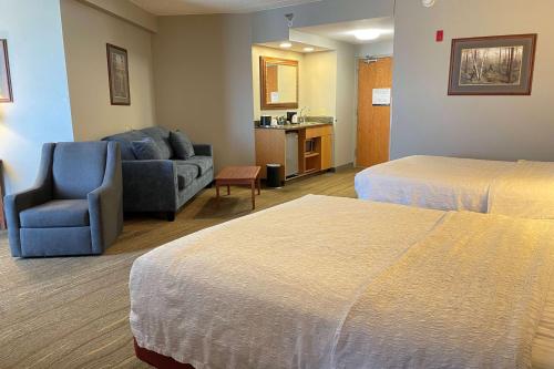 a hotel room with two beds and a couch at SouthShore Hotel on Lake Bemidji, Trademark Coll by Wyndham in Bemidji