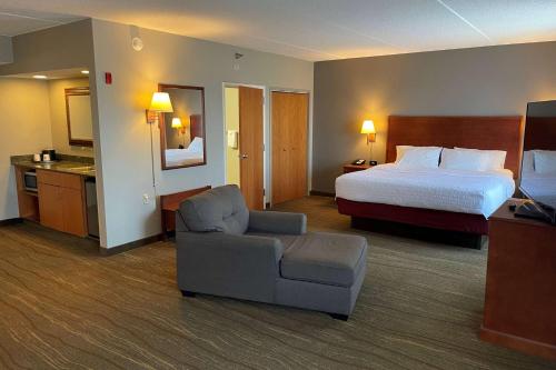 a hotel room with a bed and a chair at SouthShore Hotel on Lake Bemidji, Trademark Coll by Wyndham in Bemidji