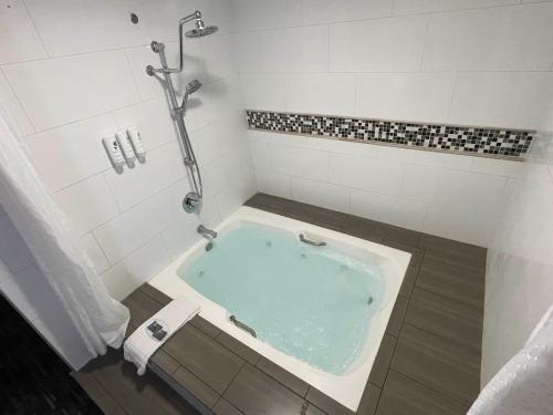a bath tub in a bathroom with a shower at Country Inn & Suites by Radisson, Bakersfield, CA in Bakersfield