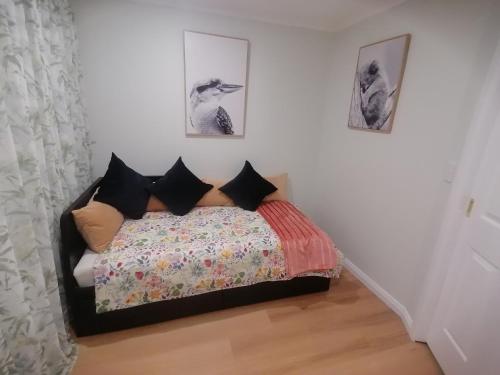a bedroom with a bed and two pictures on the wall at Maunder Cottage Aldinga Township in Aldinga