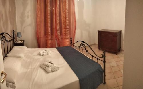 a bedroom with a bed with white sheets and a dresser at Villa Marina in Marotta