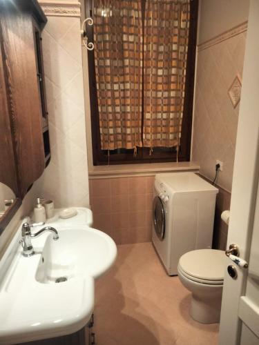 a bathroom with a white sink and a toilet at Villa Marina in Marotta