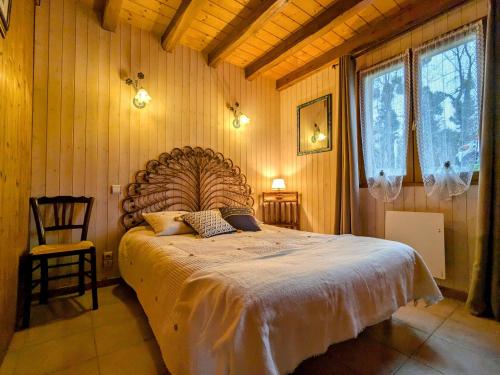 une chambre avec un grand lit dans une pièce aux murs en bois dans l'établissement Maison idéale au bord du lac avec jardin clos et parking privé, animaux admis - FR-1-591-711, à Saint-Plantaire