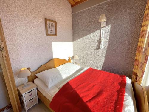 une chambre avec un lit avec une couverture rouge dessus dans l'établissement Studio familial 4 pers avec balcon, casier skis, animaux admis - FR-1-594-332, à Hauteluce