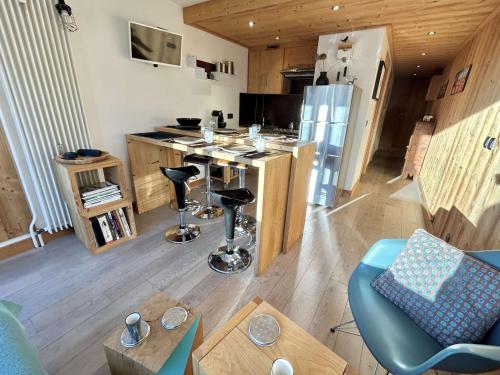 - un salon avec une cuisine équipée d'un comptoir et d'une table dans l'établissement Charmant 2 pièces + cabine à Megève, proche remontées et parking inclus - FR-1-597-185, à Megève