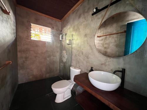 a bathroom with a sink and a toilet and a mirror at The Shack Private Beach House in Santander