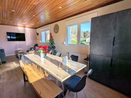 a dining room with a large wooden table and chairs at Maison spacieuse avec SPA, nature & calme dans les Vosges - FR-1-589-757 in Fraize