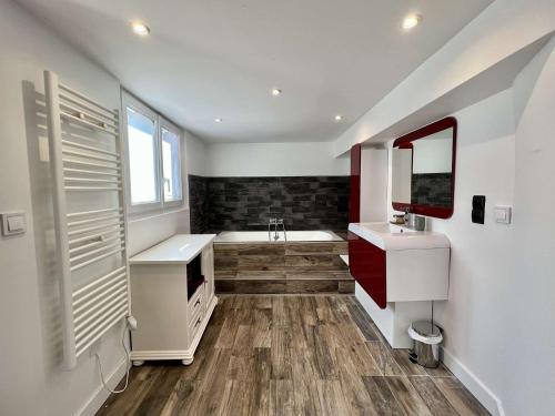 une salle de bain avec un lavabo et une baignoire dans l'établissement Maison moderne à Plouhinec avec jardin clos, Wifi, animaux admis, proche plages - FR-1-479-181, à Plouhinec