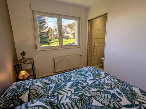 a bedroom with a bed with a colorful comforter and a window at Maison spacieuse avec SPA, nature & calme dans les Vosges - FR-1-589-757 in Fraize
