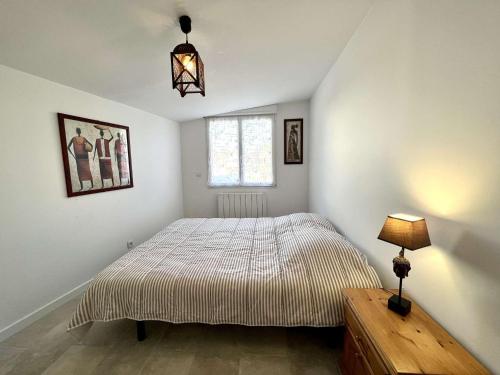 une chambre avec un lit, une lampe et une fenêtre dans l'établissement Maison moderne à Plouhinec avec jardin clos, Wifi, animaux admis, proche plages - FR-1-479-181, à Plouhinec