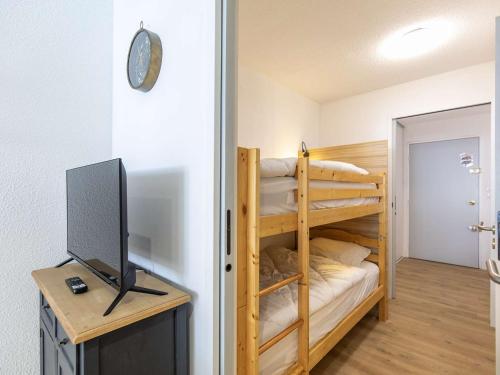 Cette chambre dispose de lits superposés et d'une télévision. dans l'établissement Studio rénové 6 pers, loggia sud, proche pistes, équipements modernes - FR-1-404-357, à La Mongie