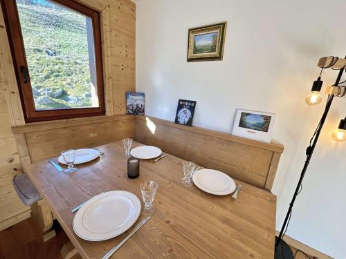 une table en bois avec des assiettes et des verres dans l'établissement Appartement 2 pièces avec cabine, terrasse sud, proche télécabine Jaillet, parking, Wi-Fi - FR-1-597-184, à Megève