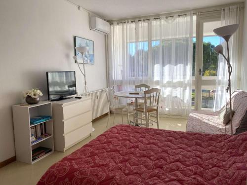 une chambre avec un lit, une télévision et une table dans l'établissement Studio confortable avec balcon et WIFI à Balaruc-les-Bains - FR-1-553-281, à Balaruc-les-Bains