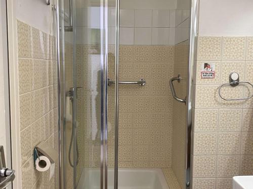 La salle de bains est pourvue d'une douche, d'une baignoire et d'un lavabo. dans l'établissement Studio confortable avec balcon et WIFI à Balaruc-les-Bains - FR-1-553-281, à Balaruc-les-Bains