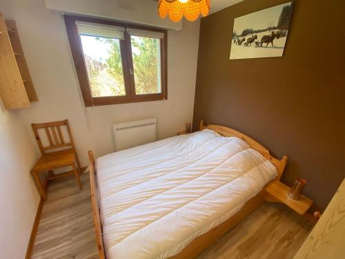 une chambre avec un lit, une fenêtre et une chaise dans l'établissement Charmant appartement à Châtel, 4 pers, parking privé, terrasse, proche centre - FR-1-693-115, à Châtel