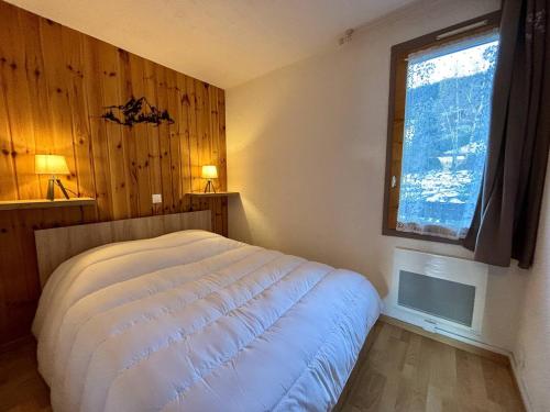 une chambre avec un lit blanc et une fenêtre dans l'établissement Appartement cosy 2 pièces, 4 pers, balcon Mont-Blanc, La Plagne - FR-1-353-153, à La Plagne Tarentaise
