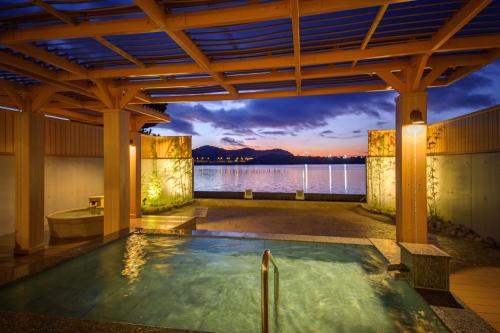 a hot tub in a building with a view of the water at Hotel Green Plaza Hamanako in Hamamatsu