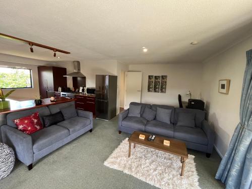 a living room with a couch and a table at The Iron Gate Family Hideaway - Pet Friendly in Cromwell