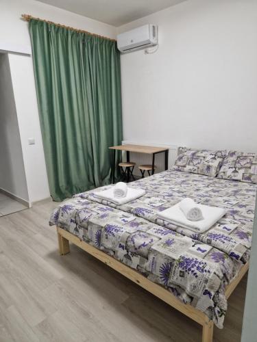 a bedroom with a bed and a green curtain at Lovely 1-room apartment self check-in in Popeşti-Leordeni
