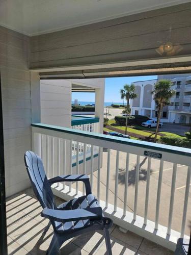 a chair on a balcony with a view of the ocean at Seawall Breeze One bedroom Condo in Galveston in Galveston