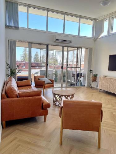 a living room with two couches and a table at Capeview 12 in South West Rocks