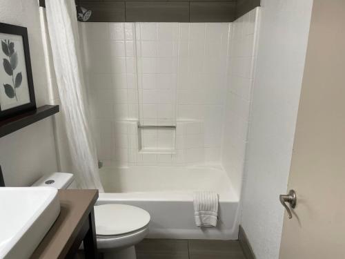 a white bathroom with a toilet and a sink at Country Inn & Suites by Radisson, Bakersfield, CA in Bakersfield