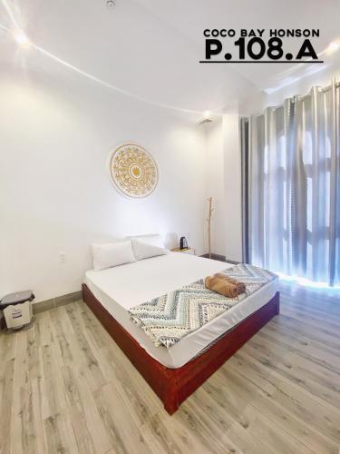 a bedroom with a bed and a wooden floor at Coco Bay Hon Son in Lai Sơn