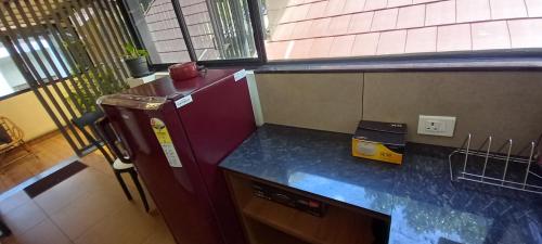 a kitchen with a purple refrigerator and a counter at Eka Homes 3BHDK Villa in Trivandrum