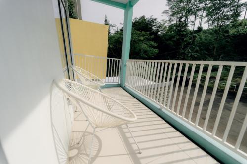 a white rocking chair sitting on a porch at Akhtar Guest House Near Situ Gede in Tasikmalaya
