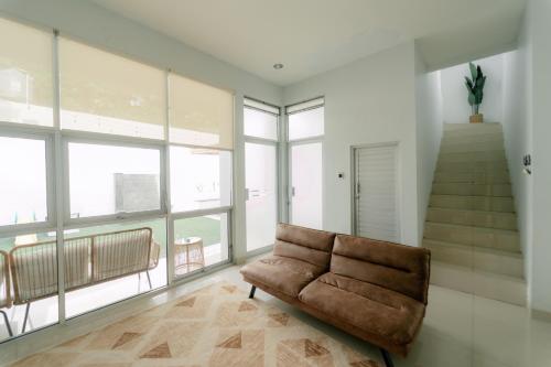 a living room with a couch and a staircase at Akhtar Guest House Near Situ Gede in Tasikmalaya
